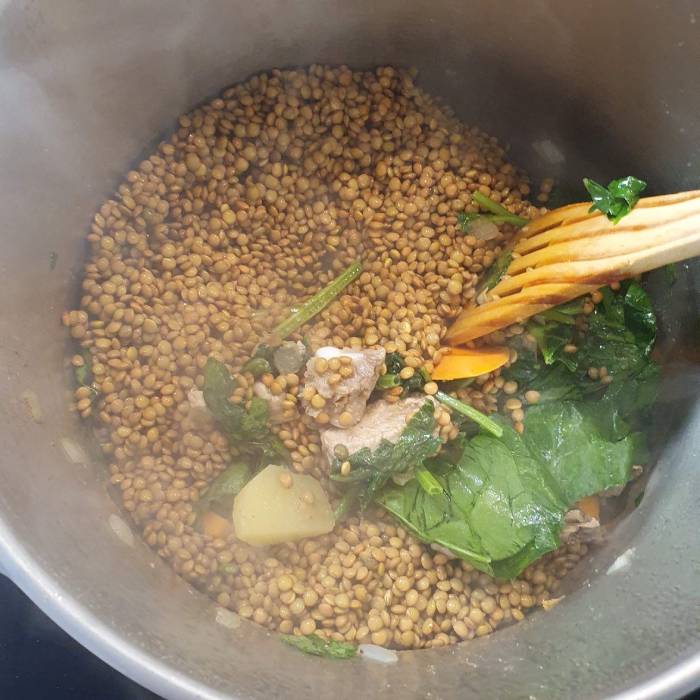 Mezclando las lentejas con todos los ingredientes antes de tapar la olla
